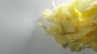 Beyaz arka plan karşı düşen patates cipsi. Ağır çekimde yüksek hızlı kamera ile çekim.