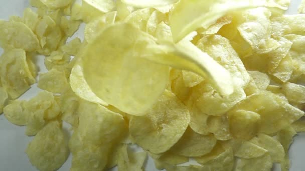 Fallende Kartoffelchips vor weißem Hintergrund. Aufnahme mit Hochgeschwindigkeitskamera in Zeitlupe. — Stockvideo