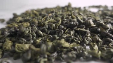 Yeşil çay beyaz zemin üzerine düşüyor. Ağır çekim