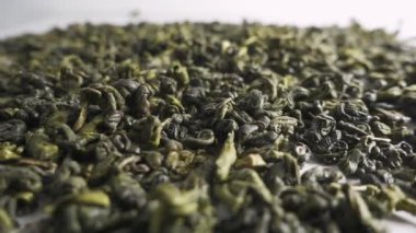 Yeşil çay beyaz zemin üzerine düşüyor. Ağır çekim