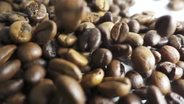 Geröstete Kaffeebohnen in einem Haufen gegossen. Zeitlupe — Stockvideo