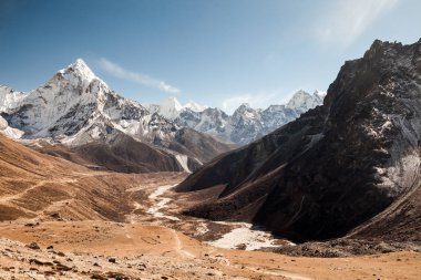 Ama Dablam dağ. Güneş yamaçlarda aydınlatır. Himalaya Dağları, Nepal.