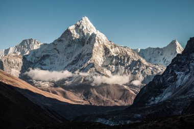 Ama Dablam dağ. Güneş yamaçlarda aydınlatır. Himalaya Dağları, Nepal.