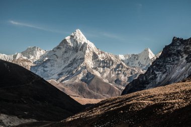 Ama Dablam dağ. Güneş yamaçlarda aydınlatır. Himalaya Dağları, Nepal.