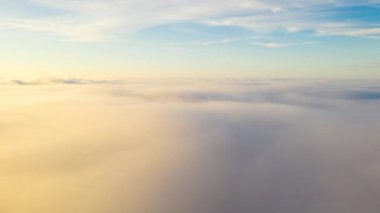 Akşam vakti bulutların üzerinde uçuyor geç güneş ile.