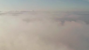 Akşam bulutlarının üzerinde uçuyor geç güneşle.