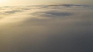 Akşam vakti bulutların üzerinde uçuyor geç güneş ile.