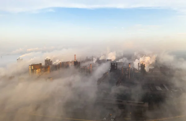 Вид с воздуха. Трубы бросают дым в небо. Большой завод на фоне города . — стоковое фото