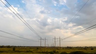 Gün batımında elektrik direklerinin zaman aşımı ve yüksek voltajlı elektrik hattı.