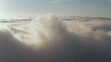 Akşam bulutlarının üzerinde uçuyor geç güneşle.