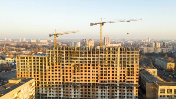 Luftaufnahme des Gebäudes während der Bauarbeiten. Arbeit auf Großbaustellen. im Hintergrund Arbeitskran und Stadt. Zeitraffer — Stockvideo