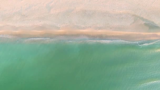 Вид с воздуха, вид сверху на волны, разбивающиеся на пляже с белым песком — стоковое видео