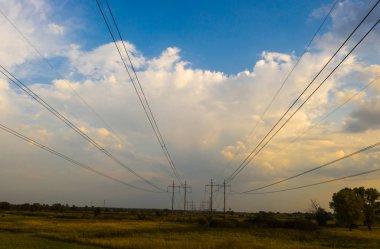 Günbatımında elektrik direkleri ve yüksek gerilim hattı.