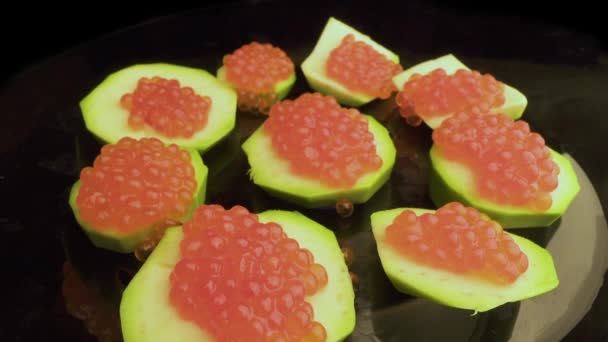 Red caviar is put with a spoon on tartlets. Preparation of snacks with red caviar. Top view. Rotation. Close up — 비디오