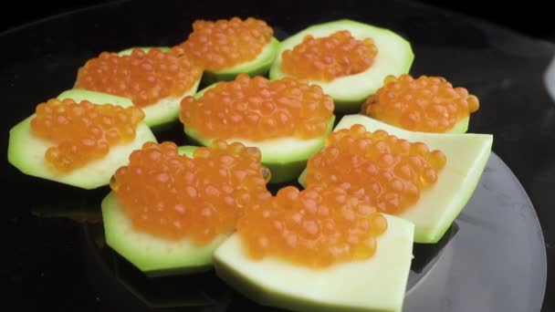 Roter Kaviar wird mit einem Löffel auf Törtchen gelegt. Zubereitung von Snacks mit rotem Kaviar. Ansicht von oben. Rotation. Nahaufnahme — Stockvideo