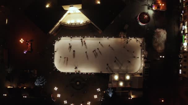 People are skating on ice rink in the evening. Aerial vertical top-down view. — 비디오