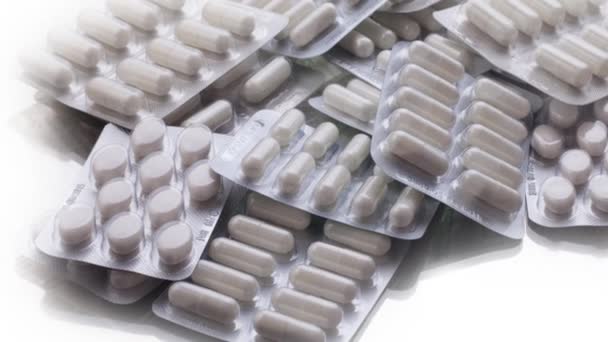 Detailní záběr různých pilulek padající na stůl s tabletami, farmaceutický průmysl koncept