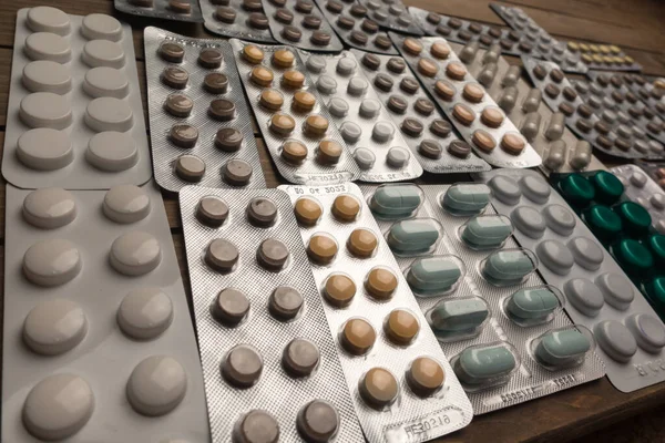 Szoros lövés a különböző tabletták az asztalon tabletta, gyógyszeripar koncepció — Stock Fotó