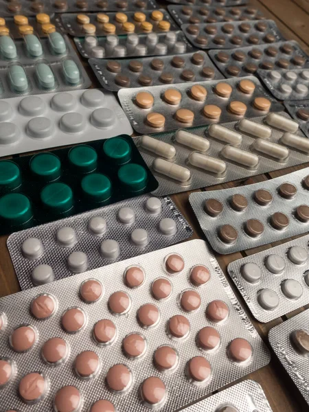 Szoros lövés a különböző tabletták az asztalon tabletta, gyógyszeripar koncepció — Stock Fotó