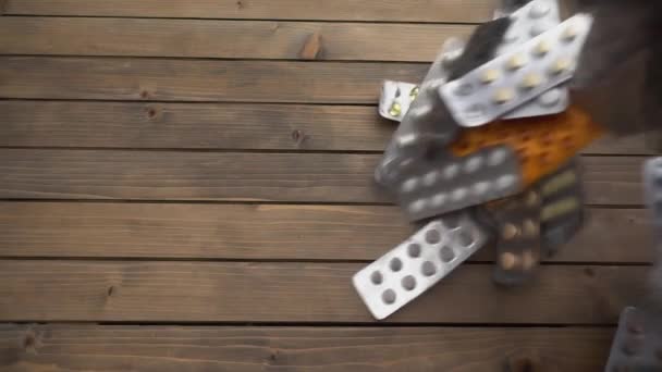 Closeup shot of different pills falling on table, pharmaceutical industry concept. — Stock Video