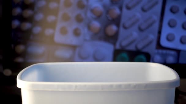 Close-up shot van verschillende pillen vallen in vuilnisbak, farmaceutische industrie concept. — Stockvideo