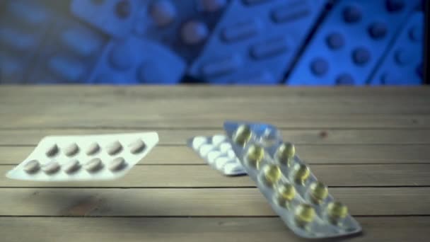 Close-up shot van verschillende pillen vallen op tafel, farmaceutische industrie concept. — Stockvideo