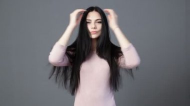 Genç esmer kadın saç okşayarak