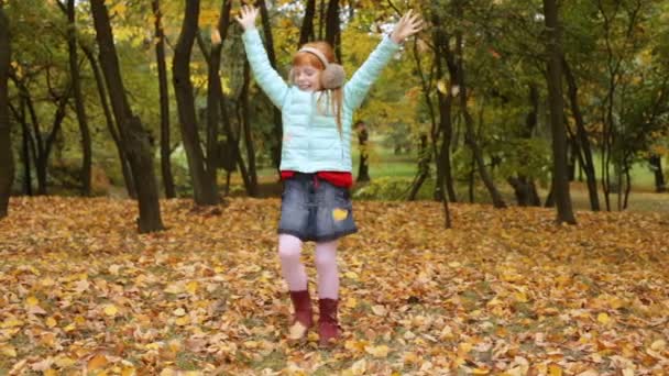 Little ginger girl playing with the autumn leaves — Stock Video