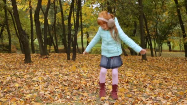 Menina gengibre brincando com as folhas de outono — Vídeo de Stock