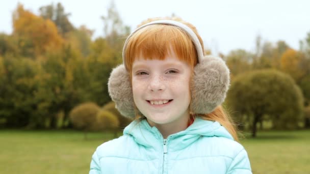 Gember meisje in de oorkappen glimlachen — Stockvideo