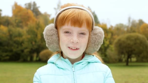 Menina de gengibre nos auriculares sorrindo — Vídeo de Stock