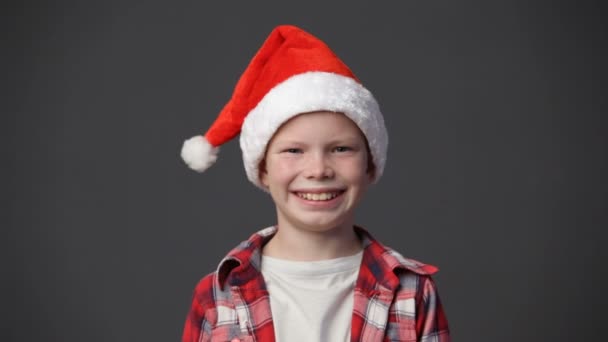 Nahaufnahme niedlicher kleiner Junge mit Weihnachtsmütze lächelnd — Stockvideo