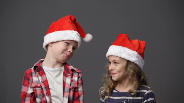 Klein meisje en jongen in Kerstmis caps — Stockvideo