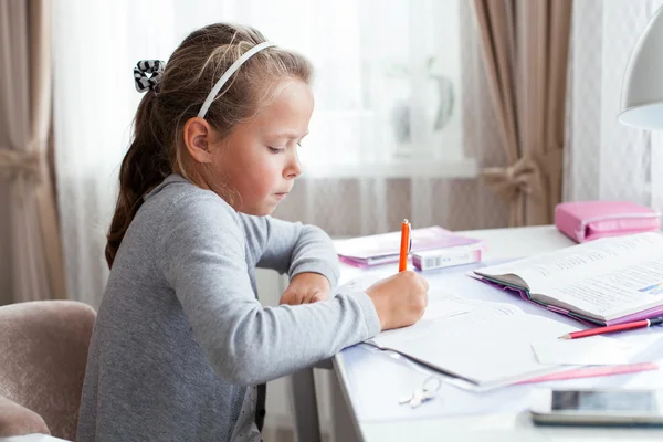 Маленька школярка робить домашнє завдання — стокове фото