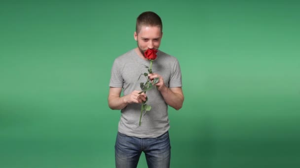 Joven hombre romántico con una rosa roja — Vídeos de Stock
