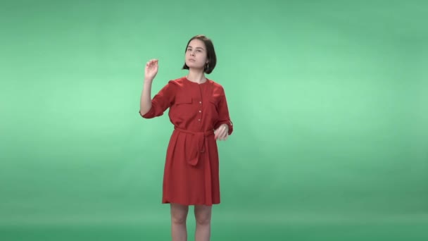 Mujer en un vestido rojo volteando la pantalla virtual — Vídeo de stock