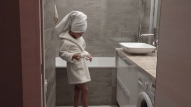 Küçük kız bir havlu ve bornoz
