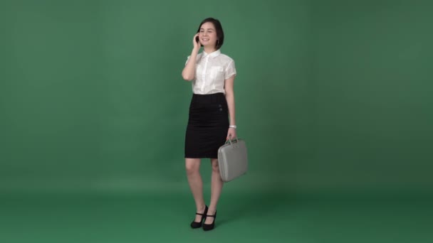 Belle femme brune en vêtements de travail parlant au téléphone — Video