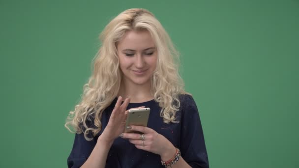 Žena při pohledu na smartphone a usmívá se — Stock video