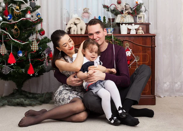 Mutlu aile Noel ağacı karşı oturuyor