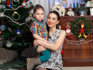 Anne kızı dizlerinin üzerinde tutuyor