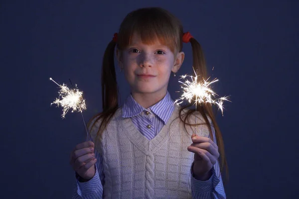 Cute little ginger girl in the vest holding the sparkles — Stock Photo, Image