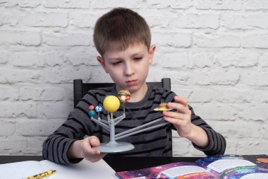 Çocuk gezegen sistemi modeli ile oynuyor