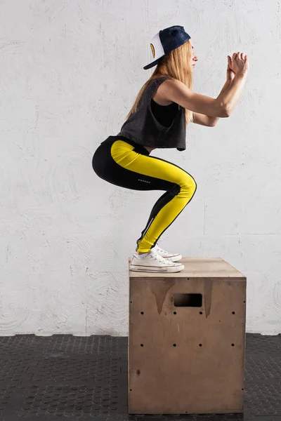 woman doing box jumps in the gym