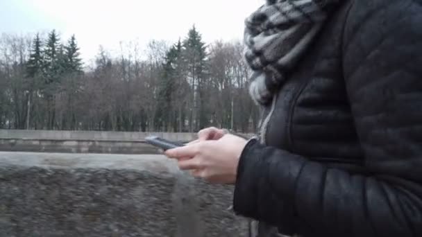 Donna che cammina lungo l'argine con smart phone — Video Stock