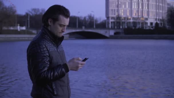 Joven con un teléfono celular al aire libre — Vídeo de stock