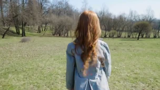 Chica pelirroja está jugando en un parque soleado — Vídeo de stock