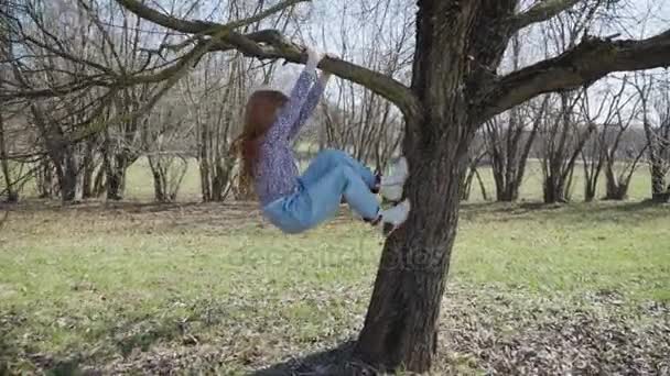Рыжая девушка играет в солнечном парке — стоковое видео
