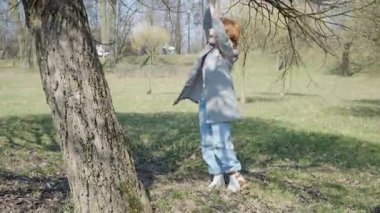 Kızıl saçlı kız güneşli parkta oynuyor