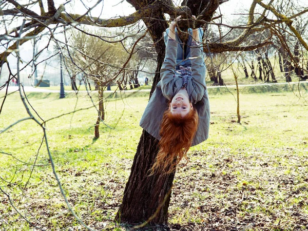 Petite fille pendue à l'envers sur un arbre — Photo